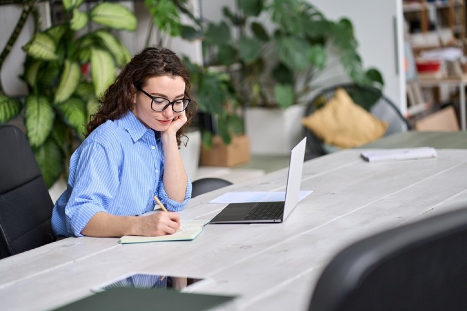Vrouw met laptop aan tafel