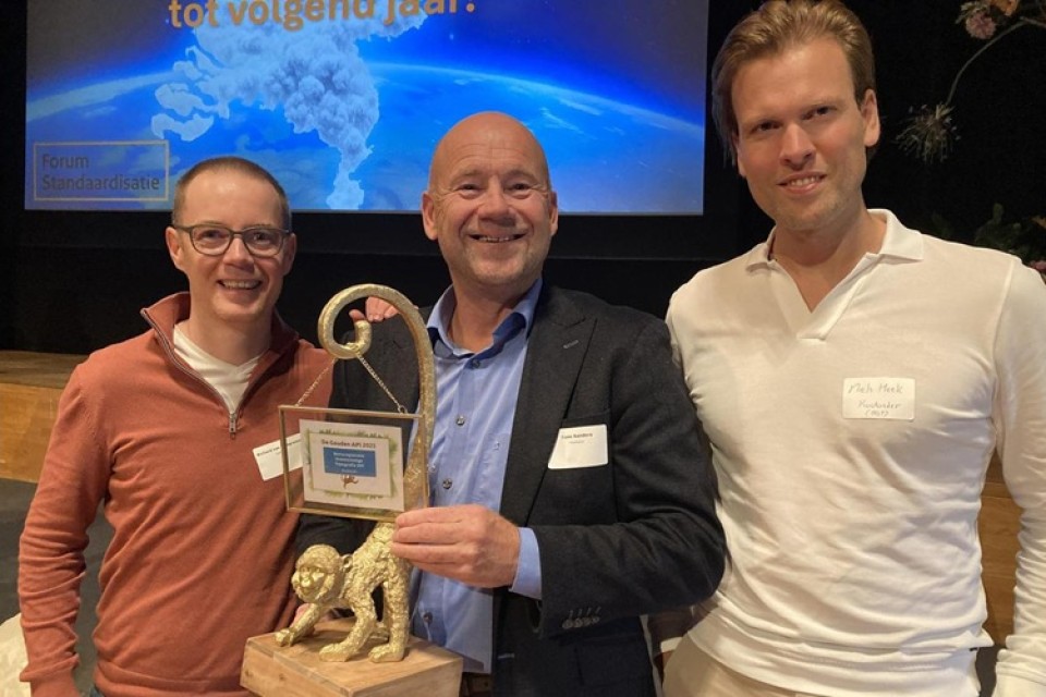 Drie mannen met de Gouden API prijs in hun handen