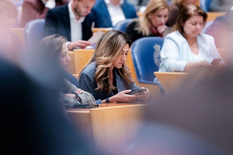 Dilan,Yesilgoz-zegerius,(vvd) op smarthone tijdens een debat in de Tweede Kamer|