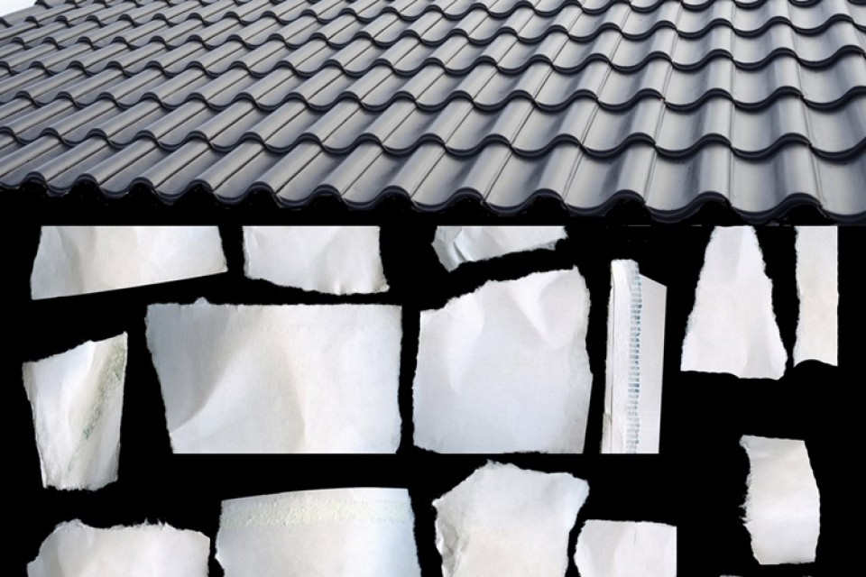 Zwart vlak met witte snippers papier, onder een donkergrijs pannendak|