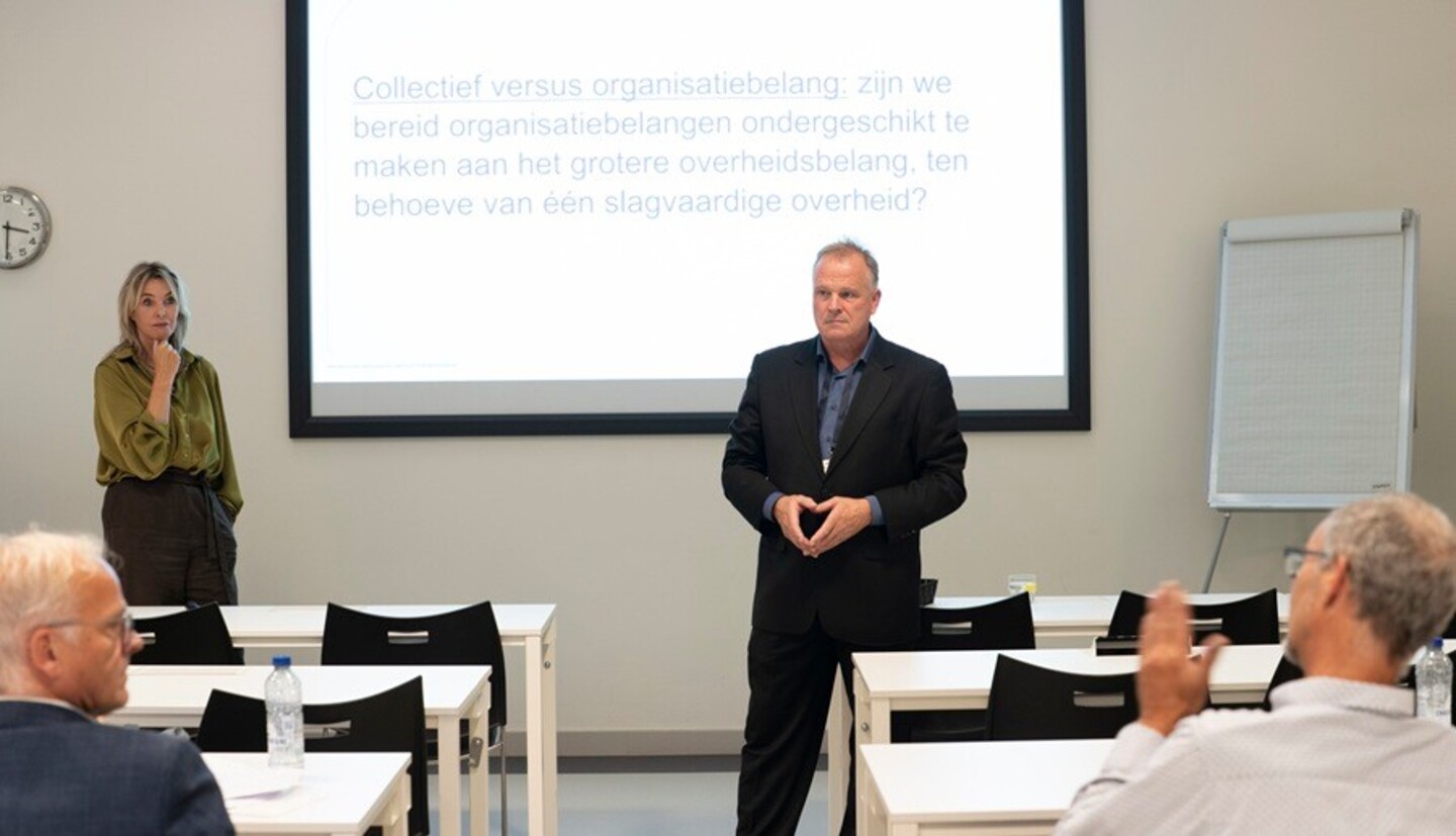 Moderator Frits Bussemaker voor een scherm met stelling