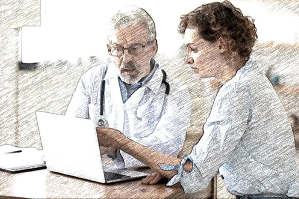 huisarts zit aan tafel met vrouwelijke patiënt|Huisarts aan tafel met patiënt