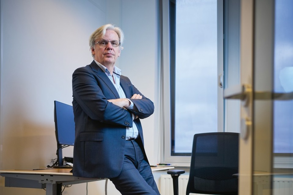 Arre Zuurmond leunt tegen zijn bureau aan