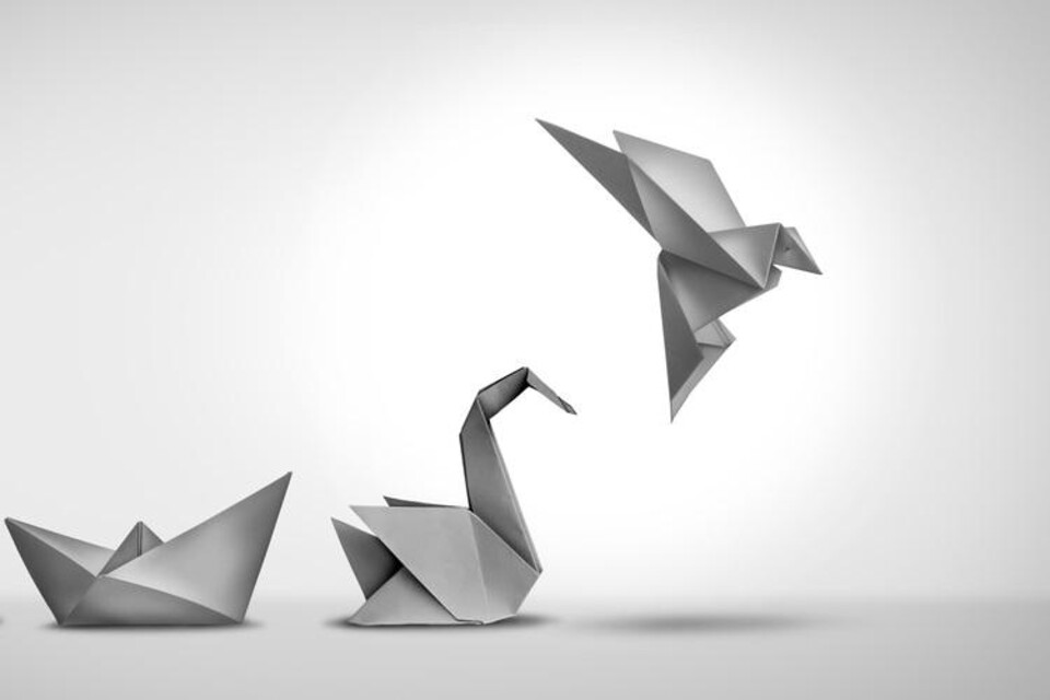 Papieren origami-zwaan stijgt op