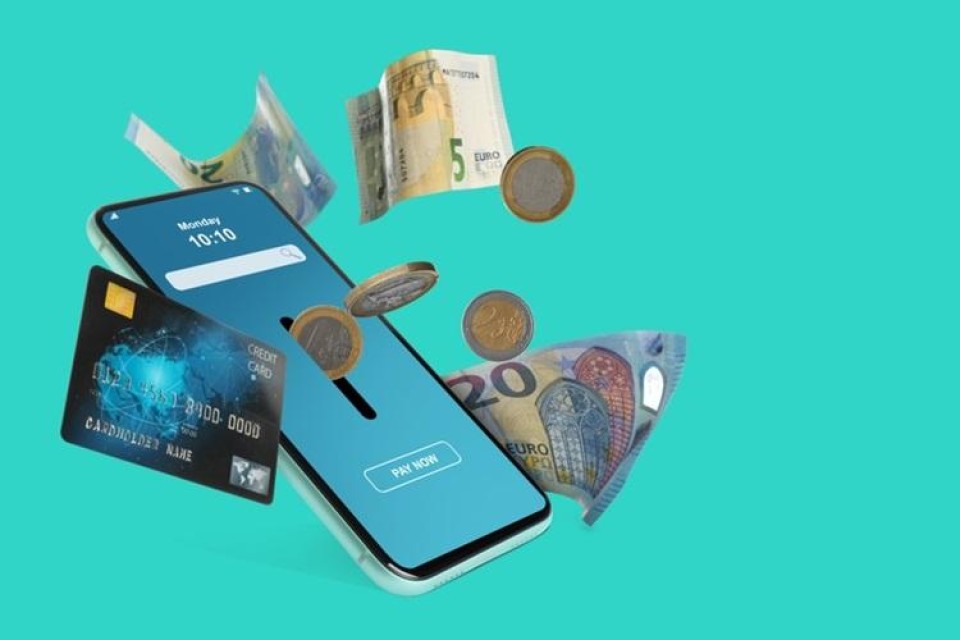 smartphone met daarvoor een creditcard en cash geld