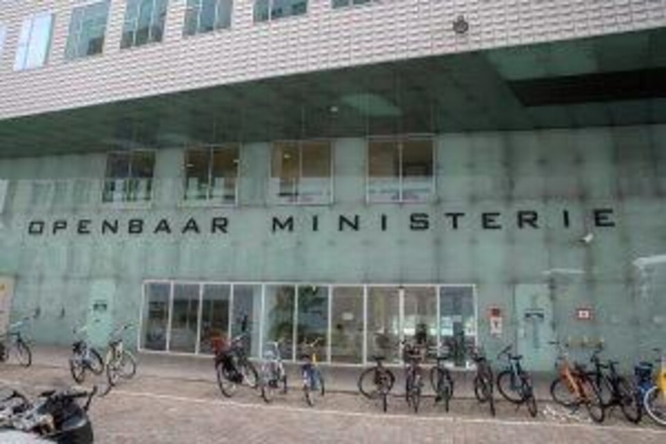 Glazen gevel van het Openbaar Ministerie met fietsen voor de ingang en een betonnen overkapping.