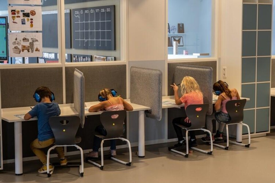 Leerlingen basisonderwijs werken aan opdrachten met koptelefoon op hun hoofd