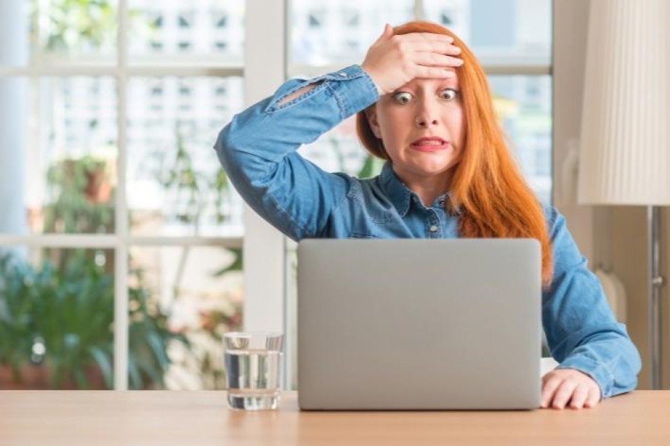 Vrouw kijkt ongerust naar laptopscherm