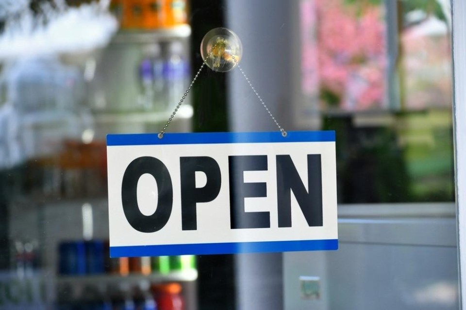 Raam waar een bordje met de tekst OPEN op hangt