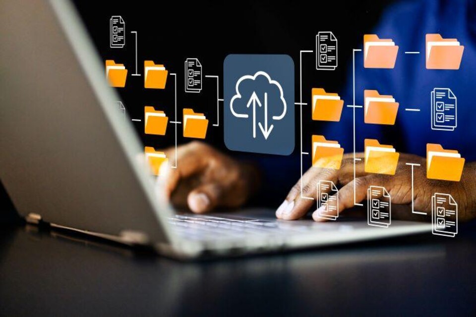 Handen typen op laptop met digitale mappen en documenten die cloudopslag en databeheer symboliseren.