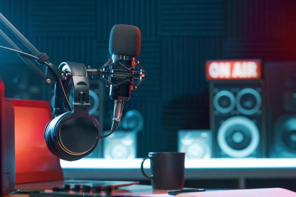 Microsoon en koptelefoon met op de achtergond een bordje 'On Air'