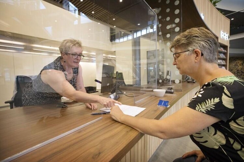 Vrouw wordt geholpen bij een loket van het gemeentehuis van in Zevenbergen
