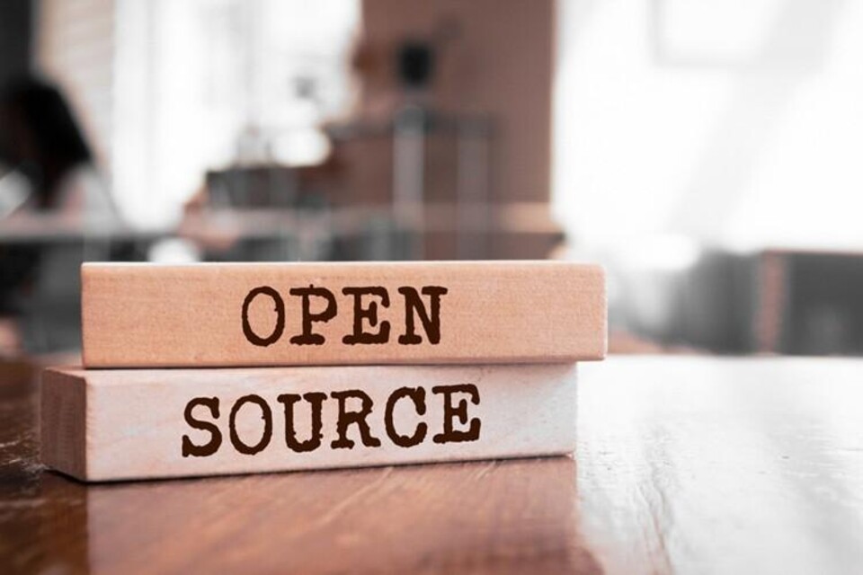 Twee houten blokken op een tafel met de tekst 'OPEN' en 'SOURCE' erop gedrukt.