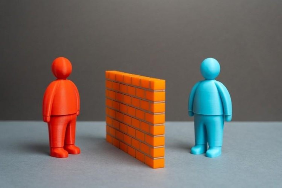 Twee poppetjes worden van elkaar gescheiden door een muur