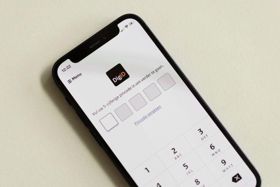 Smartphone met DigiD-app scherm voor invoer van 5-cijferige pincode en numeriek toetsenbord.