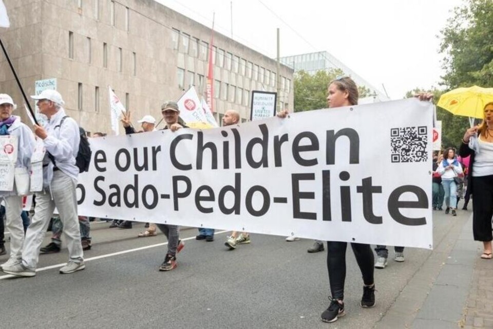 Demonstranten met een spandoek met daar op Save our Children from Sado-Pedo-Elite