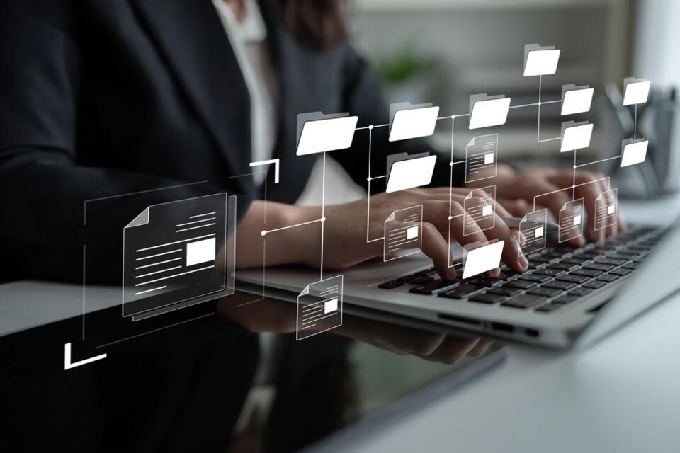 Vrouwenhanden boevn laptop, daarboven is een georganiseerde documentenstructuur geprojecteerd