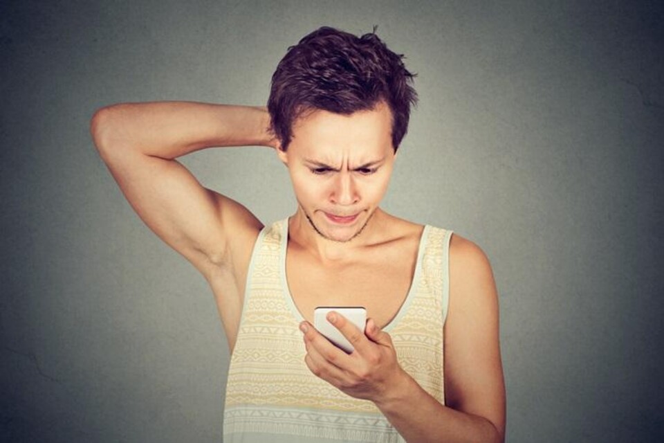 Jongen staart naar smartphone met blik vol onbegrip