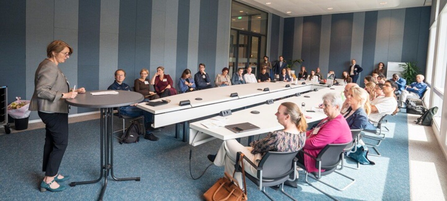 Zaaloverzicht waarin Patricia Darvis hara presentatie geeft tijdens GovTechDay, deelnemers luisteren aandachtig