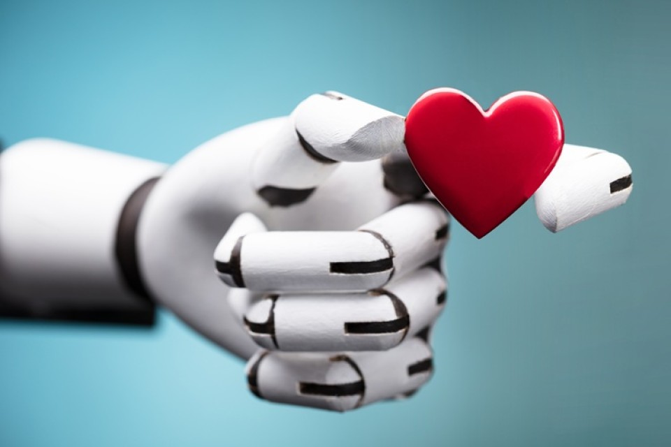 Robot hand met rood hart op blauwe achtergrond