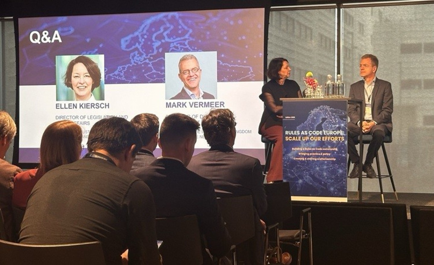 Ellen Kiersch (JenV) en Mark Vermeer (BZK) op het podium tijdens de conferentie