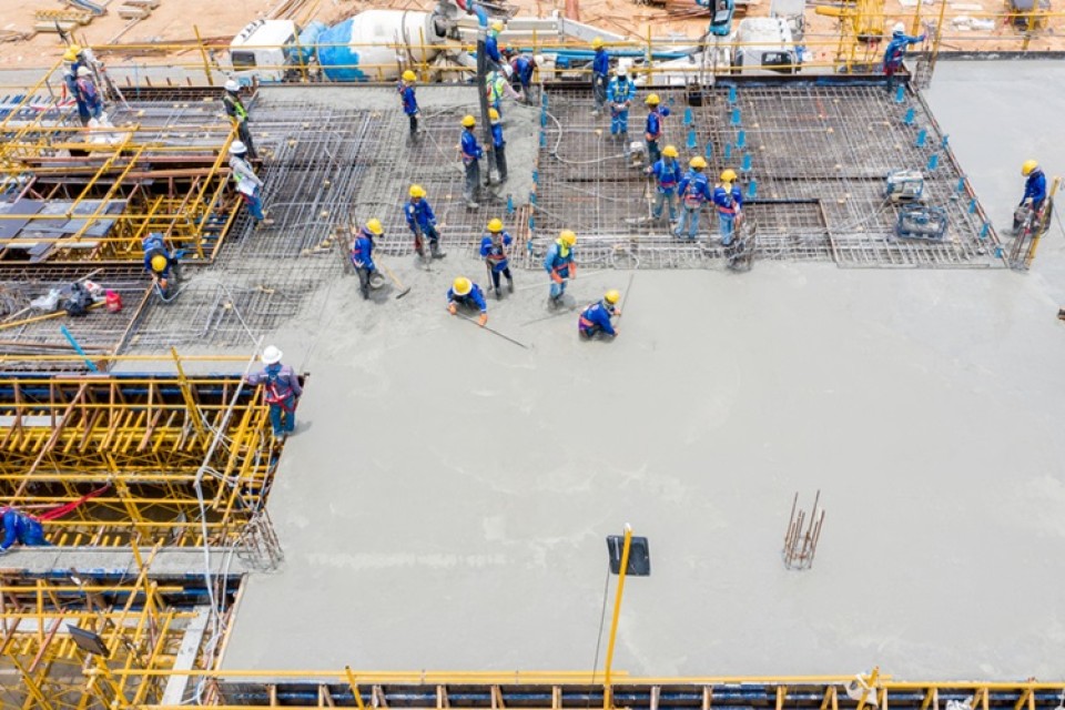 Bouwvakkers op werkplaats zijn bezig met het gieten van een betonnen vloer|Schema Dataspaces|